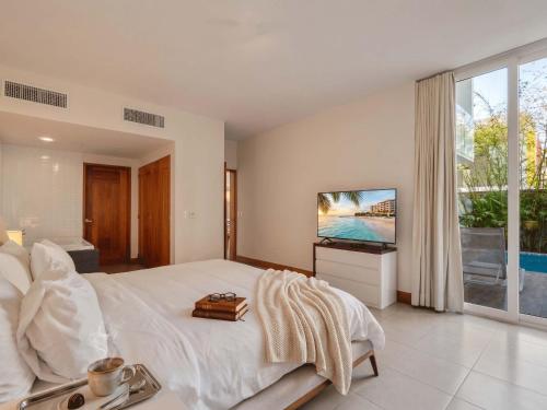 a bedroom with a large bed and a television at 3BR Beachfront Private Pool Ultravioleta Cabarete in Cabarete