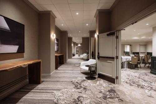 a lobby with a waiting room with chairs and tables at Loews Nashville Hotel at Vanderbilt Plaza in Nashville