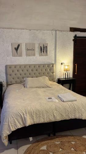 a bedroom with a large bed with a white comforter at Posada La Ernestina Villa de las rosas in Villa Las Rosas