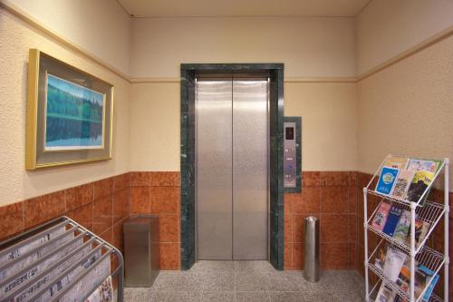 a bathroom with a metal elevator in a room at Toyooka Sky Hotel in Toyooka