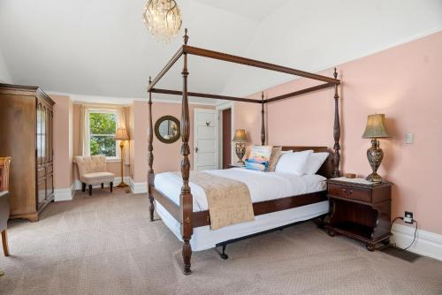 a bedroom with a four poster bed and a chair at St. Croix Valley Inn in Shafer
