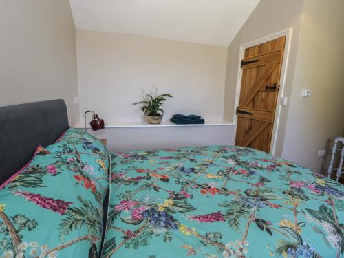 a bedroom with a bed with a colorful comforter at Beudy Bach in Llanbedr
