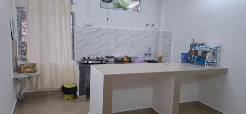 a kitchen with a white counter and a sink at Tranquil River Nest in Rupa