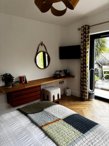 a bedroom with a bed and a mirror and a window at Barnfield house in Upham