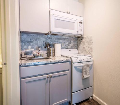 a small kitchen with a stove and a microwave at Chic AZ Studio Travel Nurses Welcome in Cashion