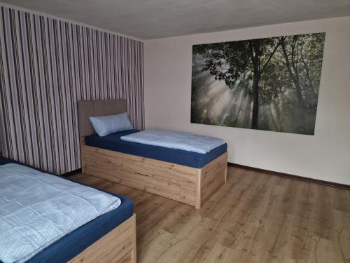 a bedroom with two beds and a painting on the wall at Ferienzimmer-Monteurzimmer in Sibbesse