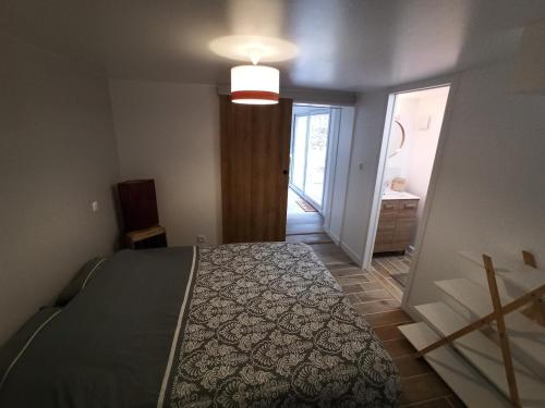 a bedroom with a bed and a door to a hallway at Le nid des mésanges in Veigné