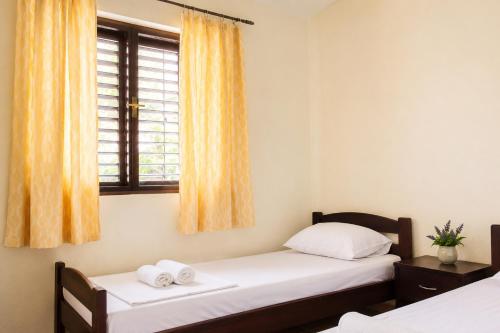 two twin beds in a room with a window at Balkan House in Mostar