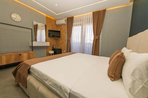 a bedroom with a large bed and a clock on the wall at DejaVu Hotel in Prizren
