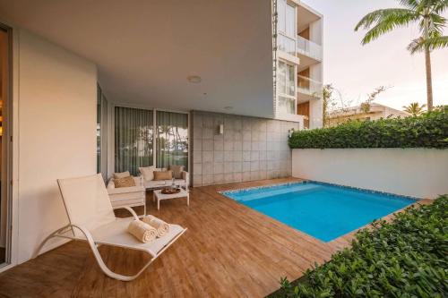 a villa with a swimming pool and a chair at Luxury 3BR Beachfront Private Pool Ultravioleta in Cabarete
