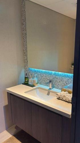 a bathroom with a sink and a large mirror at Home Sweet Home in Abu Dhabi