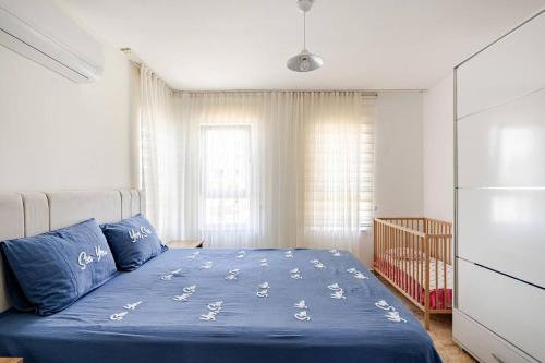 a bedroom with a bed with blue sheets and a crib at Güneş Villa in Antalya