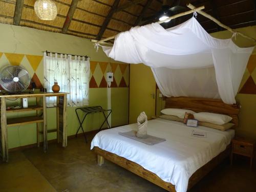 a bedroom with a bed with a mosquito net at Discovery Bed and Breakfast in Maun