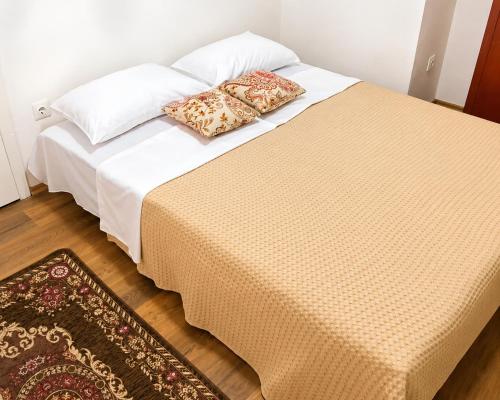 a bed with two pillows on it in a room at Balkan House in Mostar