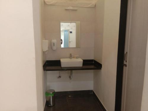 a bathroom with a sink and a mirror at Krishna's den- a cottage retreat a Gaudham Periyar Farmstay in Jambhulpāda