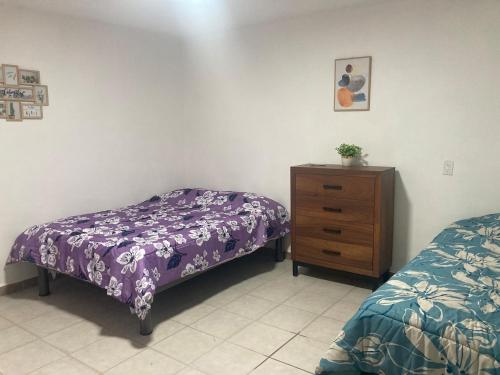 a bedroom with two beds and a wooden dresser at Casa Cangrejos in Cabo San Lucas