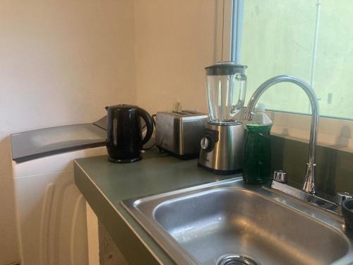 a kitchen counter with a sink and a blender at Casa Cangrejos in Cabo San Lucas