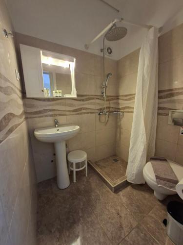 un bagno con lavandino, doccia e WC di Babis a Città di Skiathos
