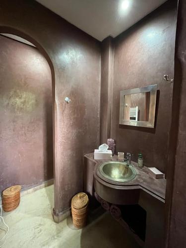 a bathroom with a sink and a mirror at Belle villa avec piscine privée in Ala el Ma