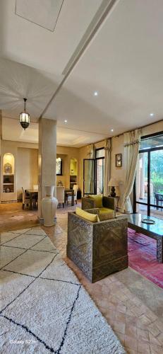 a large living room with a couch and a table at Belle villa avec piscine privée in Ala el Ma