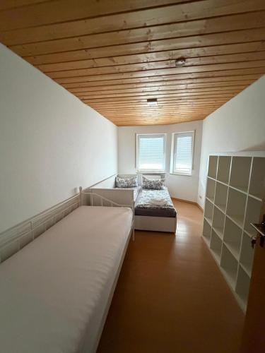 a room with two beds and a wooden ceiling at Eltons Fewo beim EuropaPark 4- Zimmer Apartment in Herbolzheim