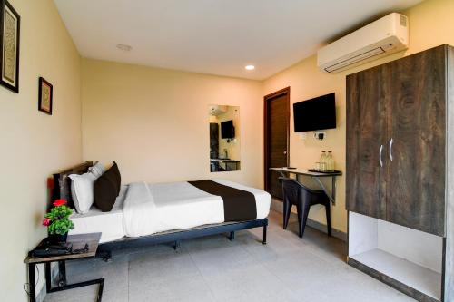 a hotel room with a bed and a desk at Hotel O Premium 12th Night in kolkata