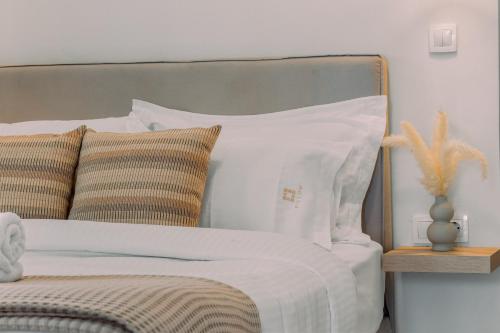 a bed with white sheets and pillows in a bedroom at Pillow Apartments in Nikiana