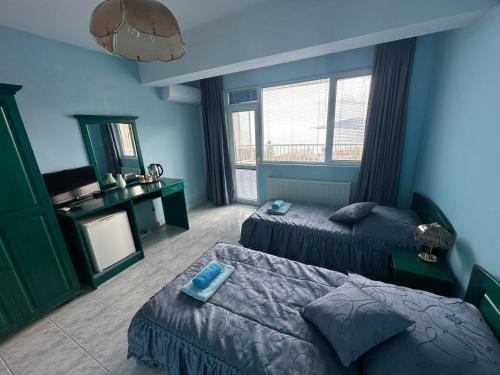a blue room with two beds and a mirror at Villa Nora in Albena