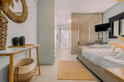 a bedroom with a bed and a table with a mirror at Pillow Apartments in Nikiana