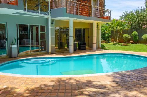 a swimming pool in front of a house at Mpala Boutique Hotel in Bulawayo
