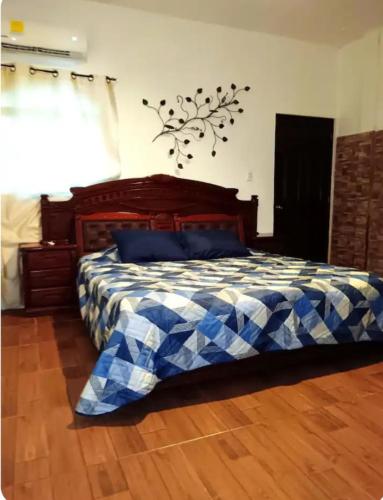 a bedroom with a bed with a blue and white blanket at Casa chalet in Chiquimula