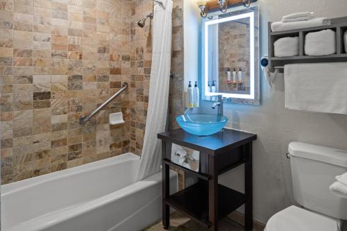 a bathroom with a sink and a toilet and a tub at Cannery Row Inn in Monterey