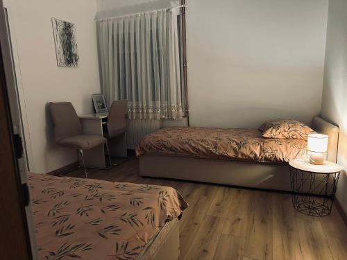a bedroom with a bed and a desk with a chair at House Burić in Otočac