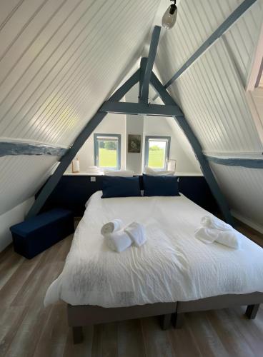 a bedroom with a white bed in a attic at Cottage de la Maye in Rue