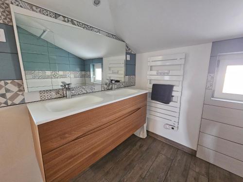 a bathroom with a sink and a large mirror at Cottage de la Maye in Rue