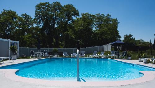 a large swimming pool with chairs and an umbrella at Circle Hotel Fairfield in Fairfield