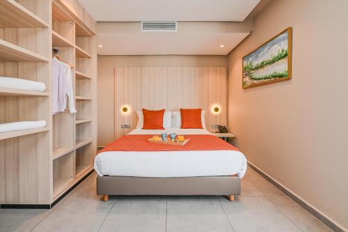 a bedroom with a large bed with orange pillows at Aruba Casablanca City Center in Casablanca