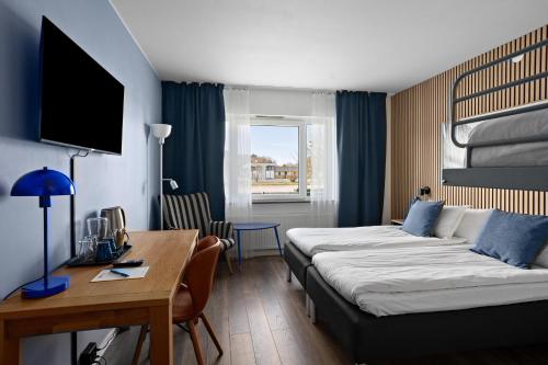 a hotel room with two beds and a desk at Best Western Eskilstuna Arena Hotel in Eskilstuna