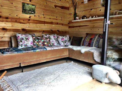 a room with a couch in a wooden wall at Forest Lounge in Petit Mesnil