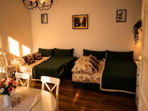 two beds in a room with a table and chairs at Siedem Światów in Jurgów