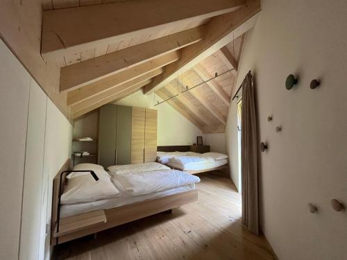 two beds in a room with wooden ceilings at The Mountain Nest in Russbach am Pass Gschütt