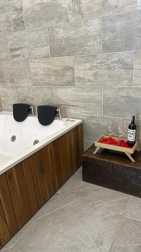 a bathroom with a tub and a table with wine glasses at La Gruta Glamping in Fúquene
