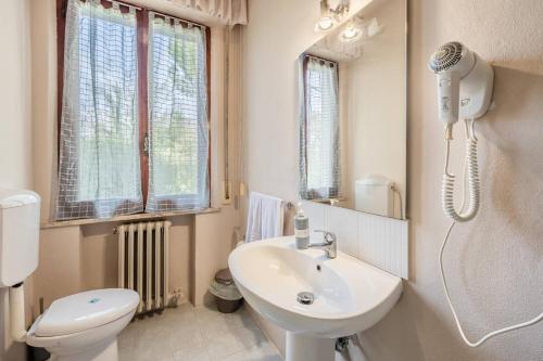 a bathroom with a sink and a toilet and a mirror at La Kasà in Fucecchio