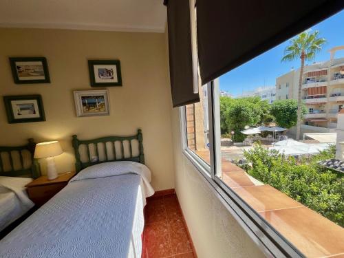 a bedroom with two beds and a large window at Luz, sol y arena in Rota