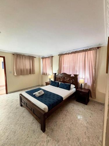 a bedroom with a large bed and two windows at Delfin Hotel Collection Rodadero in Rodadero