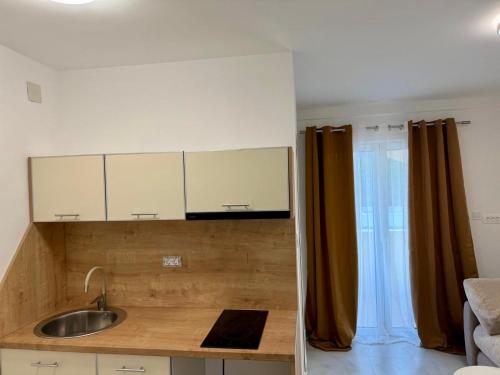a kitchen with white cabinets and a sink at Vila Lavandel in Bečići