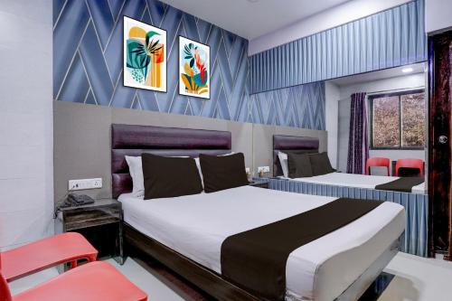 a hotel room with two beds and red chairs at Hotel O Jayesh Inn in Kolshet