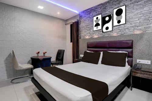a bedroom with a bed and a table and a chair at Hotel O Jayesh Inn in Kolshet