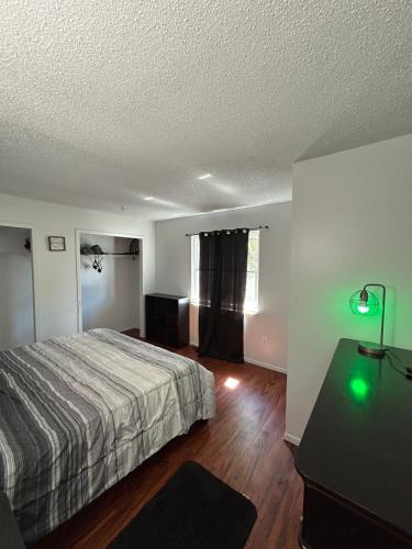 a bedroom with a bed and a table with a lamp at Plum Cozy Spot in Seffner