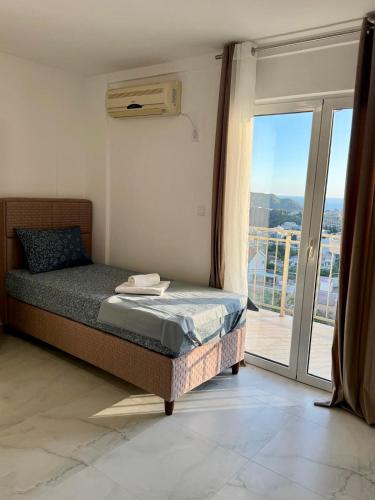a bedroom with a bed and a sliding glass door at Vila Lavandel in Bečići